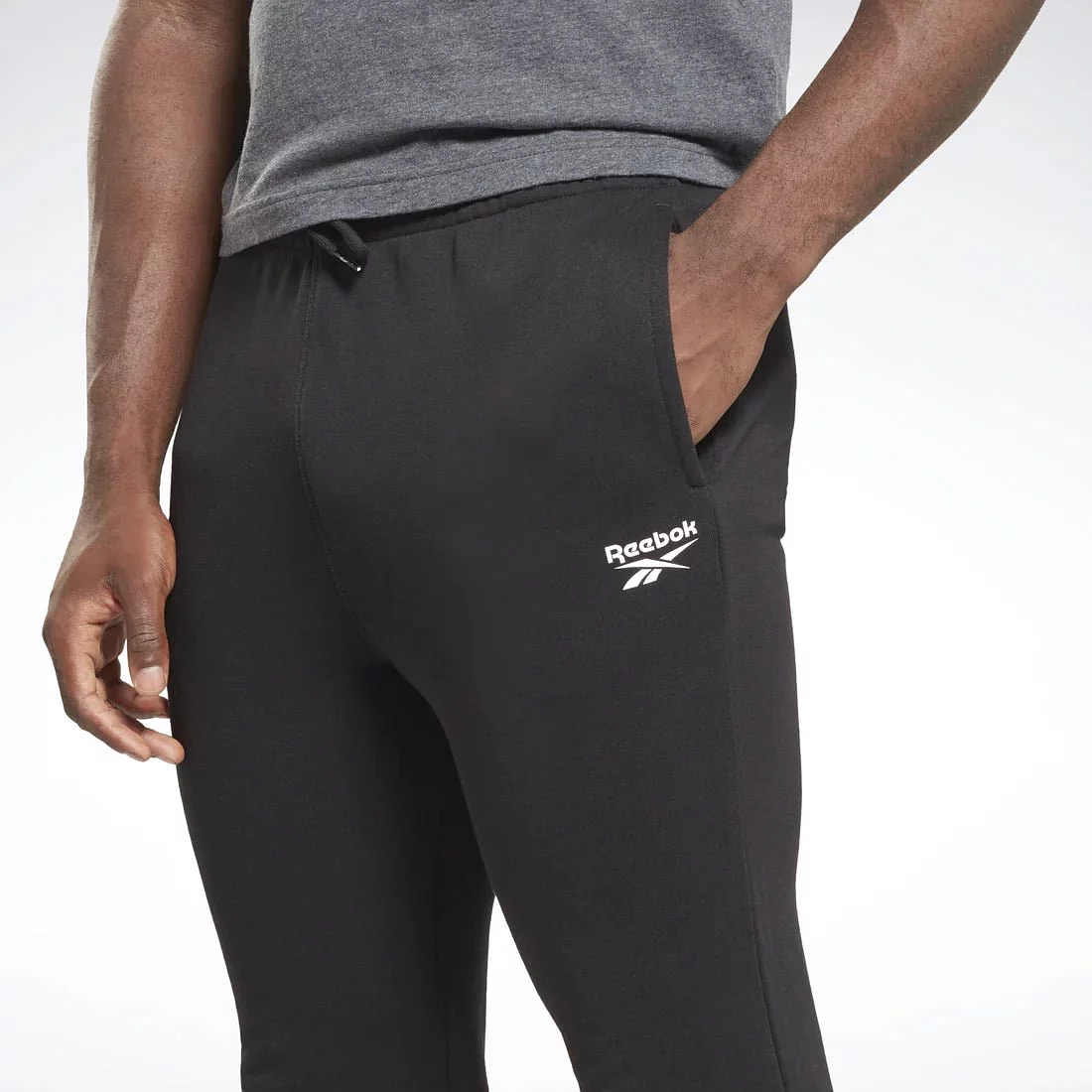 Reebok men's black trackpants with small vector design.